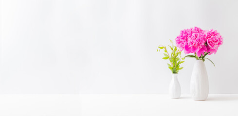 Minimalist home interior with decor elements. Pink peonies in a vase on a light background