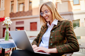 Smiling woman typing on laptop during workday