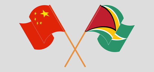 Crossed and waving flags of China and Guyana