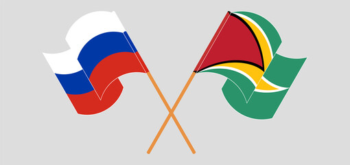 Crossed and waving flags of Russia and Guyana