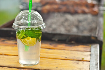 Green mojito on a grill background. Cocktail with lime and mint. The concept of summer outdoor recreation and festivals.