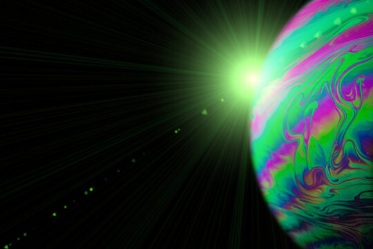 Bubbles macro. Globe planet earth in galaxy universe space with abstract sun on black background. Macro of oil mixed with water.