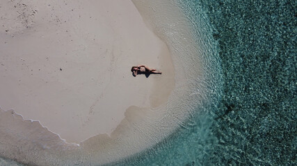 Mature lady on vacation laying on a tropical beach