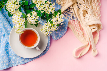 Beautiful natural spring background with space for text on a pink table with a cup of tea