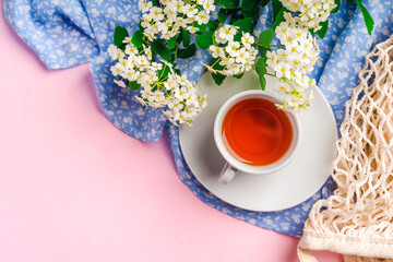 Beautiful natural spring background with space for text on a pink table with a cup of tea