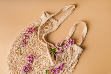 Organic and reusable cotton eco-friendly bag with spring flowers, top view. Beautiful minimalistic floral composition