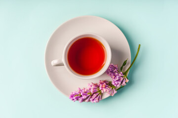 Beautiful minimalist background with floral composition and tea mug, copy space on light blue backround