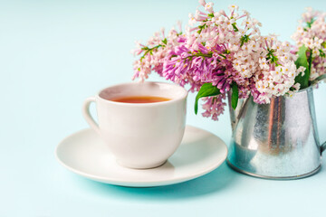Obraz na płótnie Canvas Beautiful minimalist background with floral composition and tea mug, copy space on light blue backround