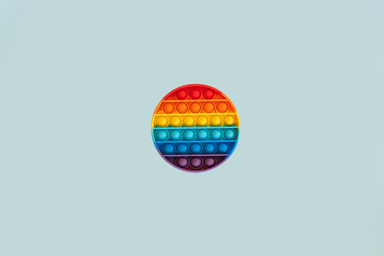 Antistress pop it toy. New popular silicone colorful antistress popit toy for child on blue background. Top view. Copy space for text.