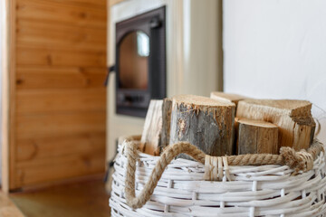 Fototapeta na wymiar Basket with firewood near country furnace in Estonia Hiiumaa