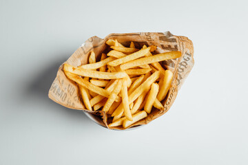 View on freshly fried fries in bowl on bright backgroud