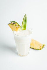 Fresh traditional caribbean cocktail pina colada with pinaple slice on bright background