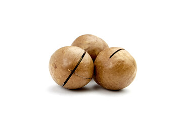 Fototapeta premium Roasted macadamia nuts isolated on white background. Three unshelled macadamia nuts