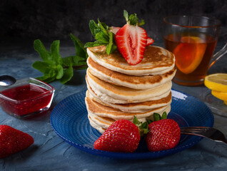 Pancakes with strawberries. Pancakes for breakfast. American pancakes. Sweet breakfast with pancakes.