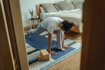 Frau macht Yoga Sonnengruß zuhause