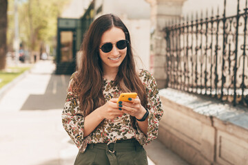 A picture of a young woman enjoying her time talking with someone on her phone while walking