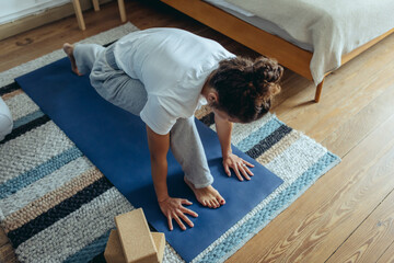 Frau macht Yoga am Morgen im Schlafzimmer