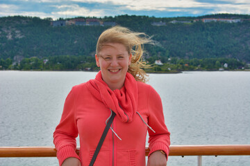 Junge Frau lächelt und steht auf einem Kreuzfahrtschiff