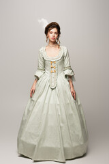 full length view of young woman in elegant retro dress isolated on grey