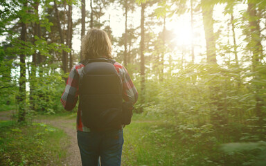 Man with backpack and sunglasses in the woods. Arc shoot.
