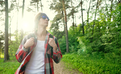 Man with backpack and sunglasses in the woods. Arc shoot.