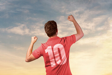 man in football shirt celebrating with beautiful sky