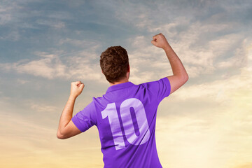 Fototapeta na wymiar man in football shirt celebrating with beautiful sky