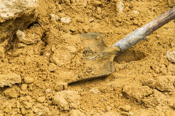 Close up shovel with sand during construction work. Working environment at the construction site