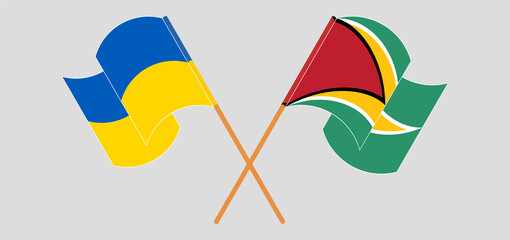 Crossed and waving flags of Ukraine and Guyana