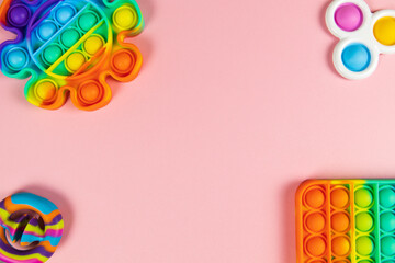 Anti-stress toys pop it, simple dimple, snapperz on pink background, copy space. Concept trendy entertainment for fidget children, sensory toys, development of fine motor skills, stress relieving