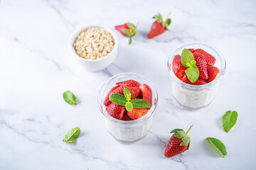 Oatmeal porridge with milk and fresh strawberries in a glass