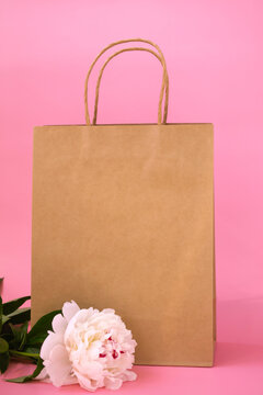 Gift eco bag with copy space on colored background with white beautiful peony. Gift concept. Vertical photo