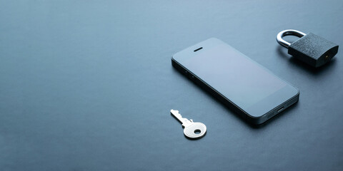 Mobile security. Modern space grey mobile phone with padlock, key on dark background. Identity theft and cyber security concept.