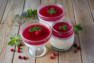 Italian dessert: panna cotta with cranberry sauce on a wooden table