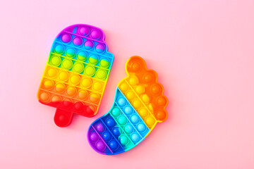 Colorful antistress silicone toys fidget push pop it on pink background