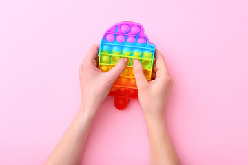 Colorful antistress silicone toy fidget push pop it on pink background