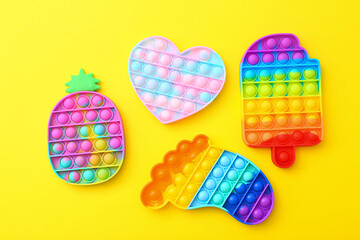 Colorful antistress silicone toys fidget push pop it on yellow background