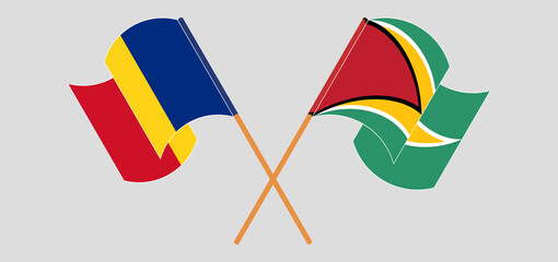 Crossed and waving flags of Romania and Guyana