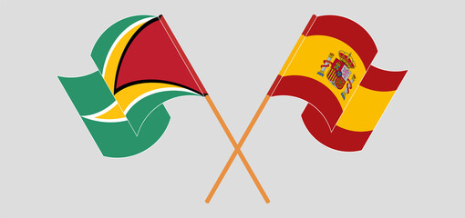 Crossed and waving flags of Guyana and Spain