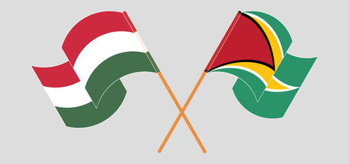 Crossed and waving flags of Hungary and Guyana