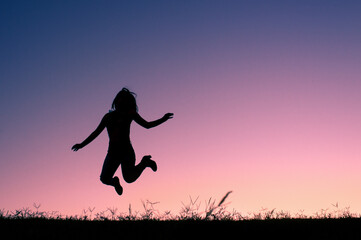 Girl Jumping with Blue and Purple Sky