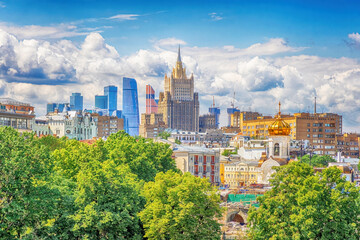 Fototapeta premium Summer bright Moscow city cityscape with beautiful clouds. Residential urban development in the foreground and the Foreign Ministry building with the Moscow City business center in the background