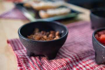 Chopped pork in black bowl above checkered napkin