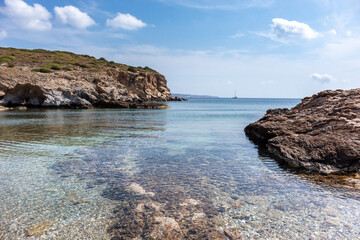 Fototapeta na wymiar Wild mediterranean sea with rocky shore, blue clear water and nice sky. Travel Greece near Athens. Summer nature scenic lagoon