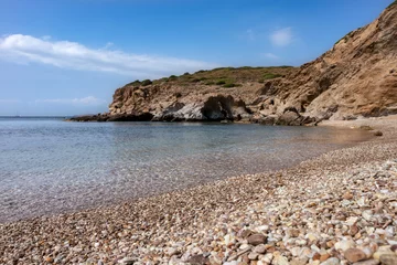 Foto op Plexiglas anti-reflex Wild mediterranean sea pebble beach close-up with rocky cliffs shore and blue clear water. Travel Greece near Athens. Summer nature scenic lagoon © Kathrine Andi