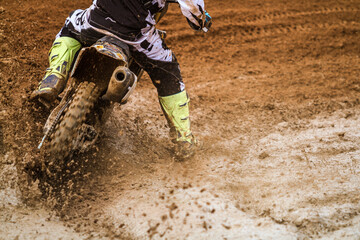 Close up of motocross racer accelerating in dirt track - obrazy, fototapety, plakaty