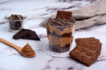 sweet desserts chocotorta and chiskey with cookies sweet milk and red fruit jam in glasses on light marble countertops