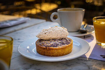 Close-up of cinnamon dessert with cup of coffee behind.