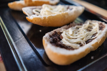 Three traditional Mexican molletes on a black tray