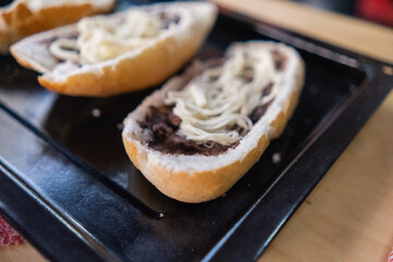 Three traditional Mexican molletes on a black tray